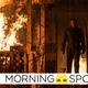 Michael Myers, weapon in hand, escapes a burning house in a scene from Halloween Kills.